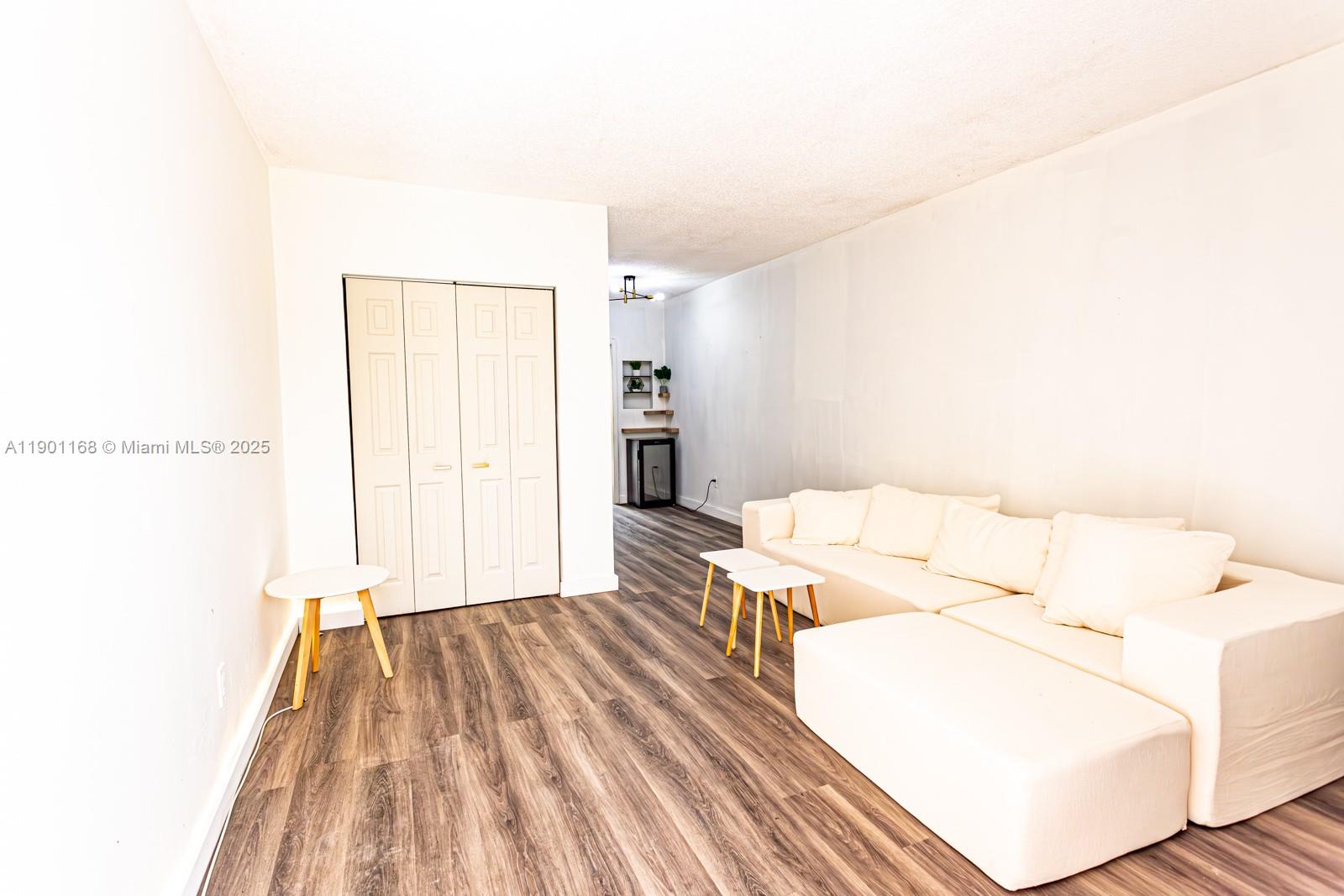 7720 Harding Avenue, Unit 3 Miami Beach, FL 33141 - Photo 3 of 15 a living room with furniture and a wooden floor