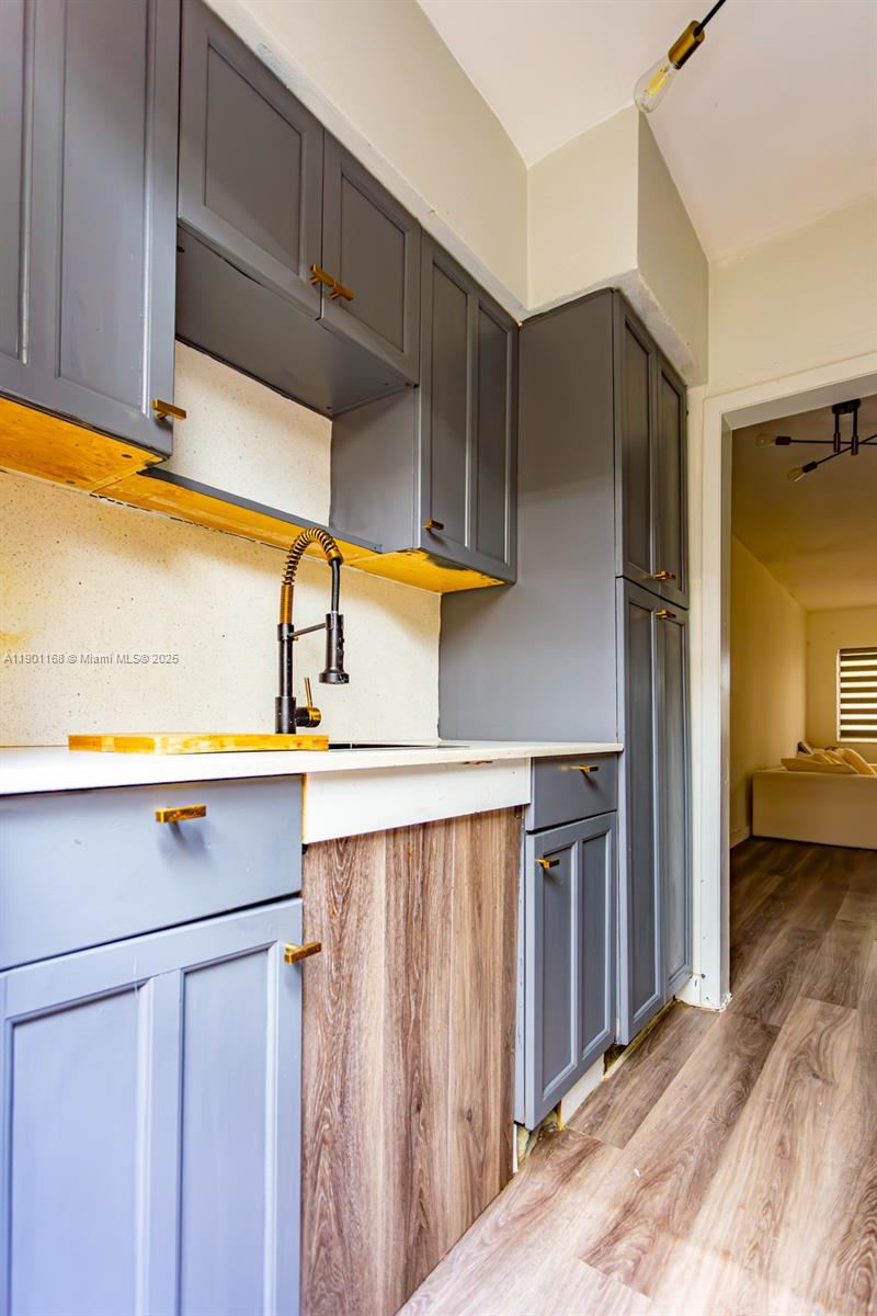 7720 Harding Avenue, Unit 3 Miami Beach, FL 33141 - Photo 7 of 15 a kitchen with a sink a refrigerator and cabinets