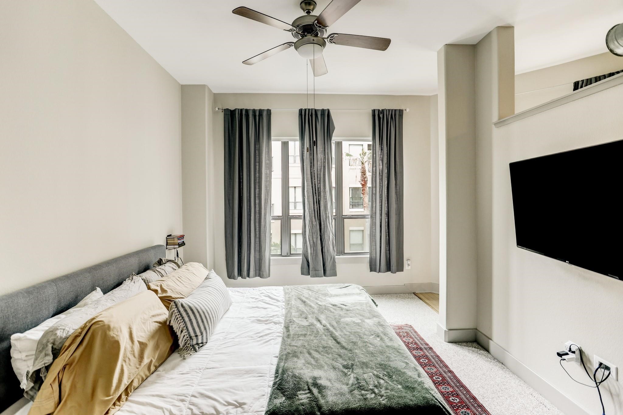 1901 Post Oak Boulevard, Unit 3502 Houston, TX 77056 - Photo 4 of 14 a bedroom with a bed and a flat tv screen