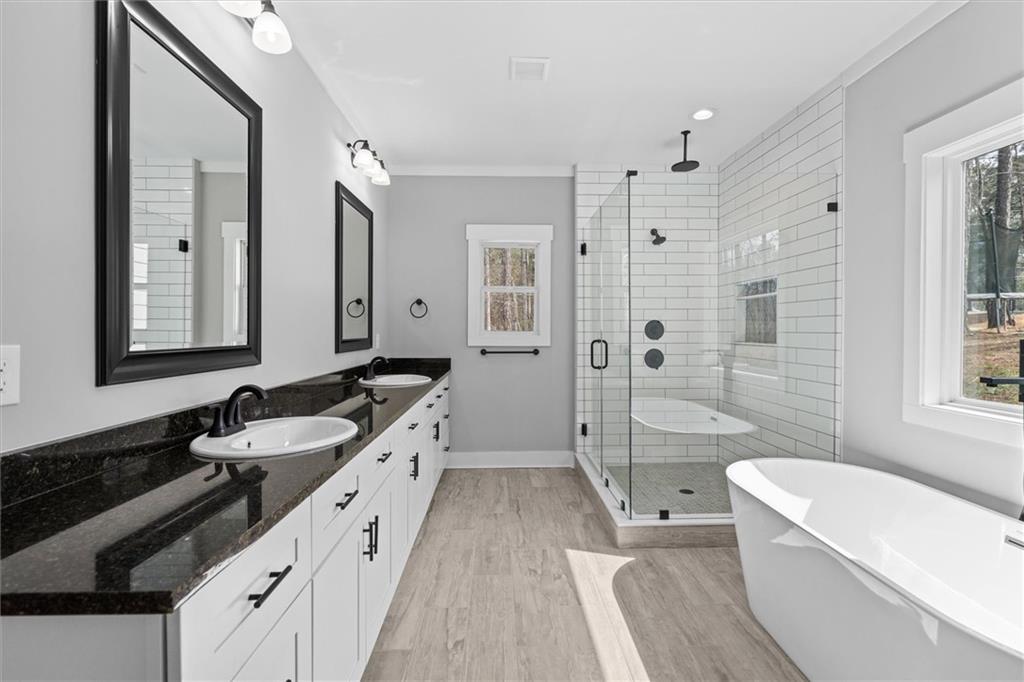 6093 Wayfarer Drive Villa Rica, GA 30180 - Photo 23 of 70 a spacious bathroom with a double vanity sink a mirror a bathtub and shower