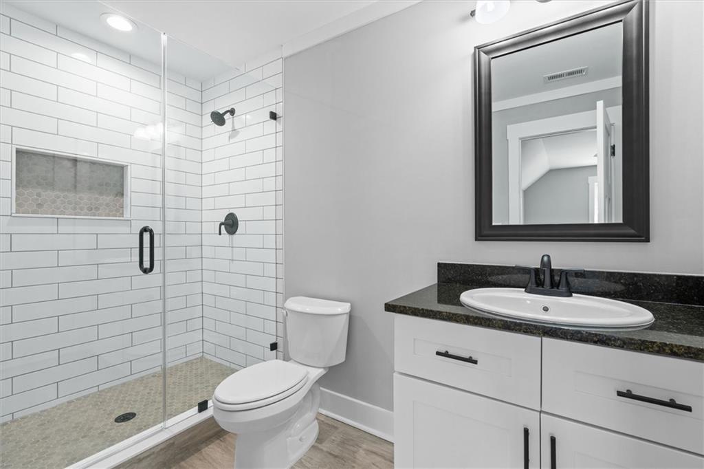 6093 Wayfarer Drive Villa Rica, GA 30180 - Photo 35 of 70 a bathroom with a granite countertop toilet sink shower and mirror
