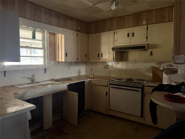 a kitchen with stainless steel appliances granite countertop a sink stove and cabinets