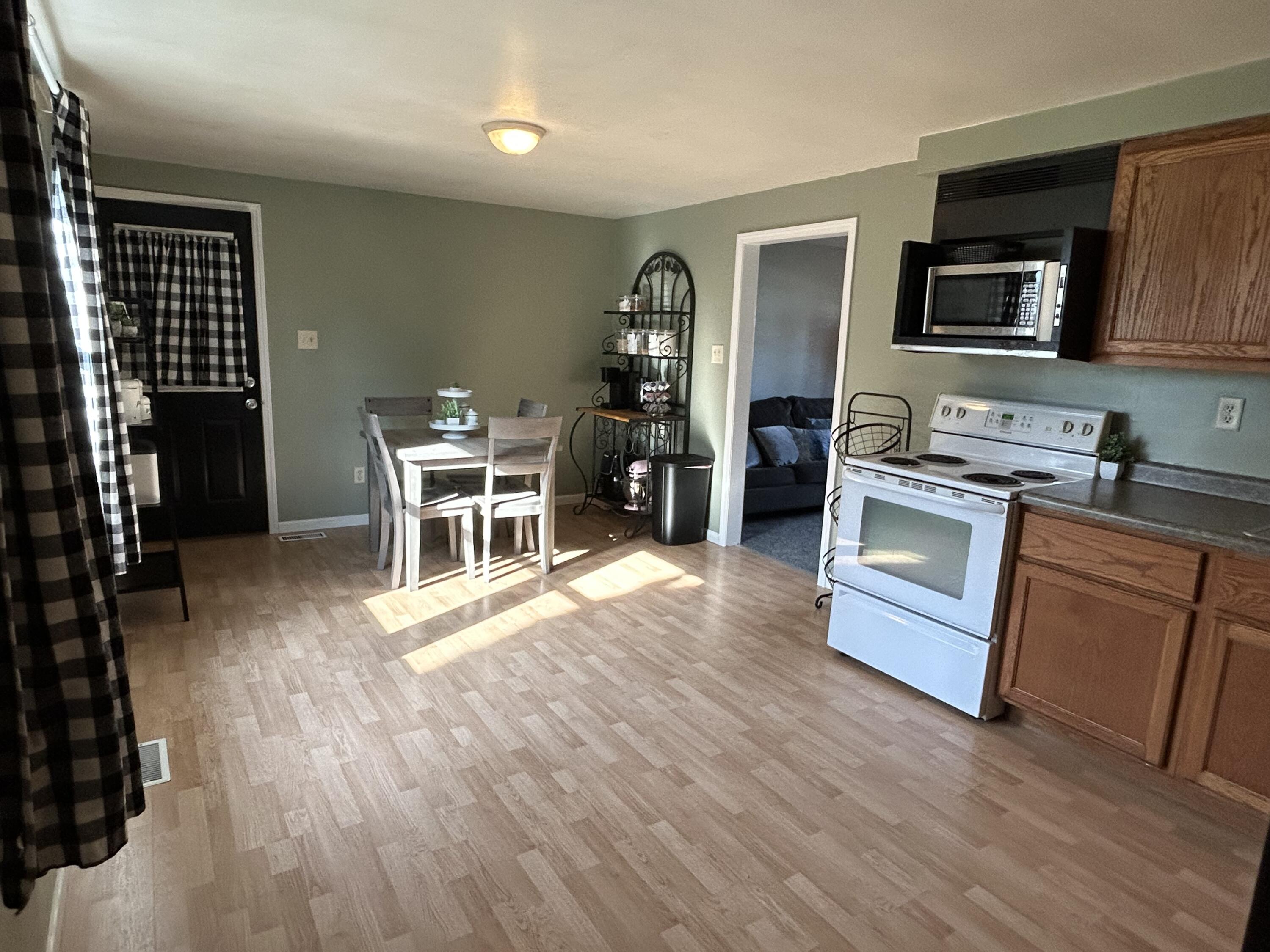 502 North Webster Street Rensselaer, IN 47978 - Photo 7 of 35 a kitchen with stainless steel appliances granite countertop wooden floors a stove and a microwave