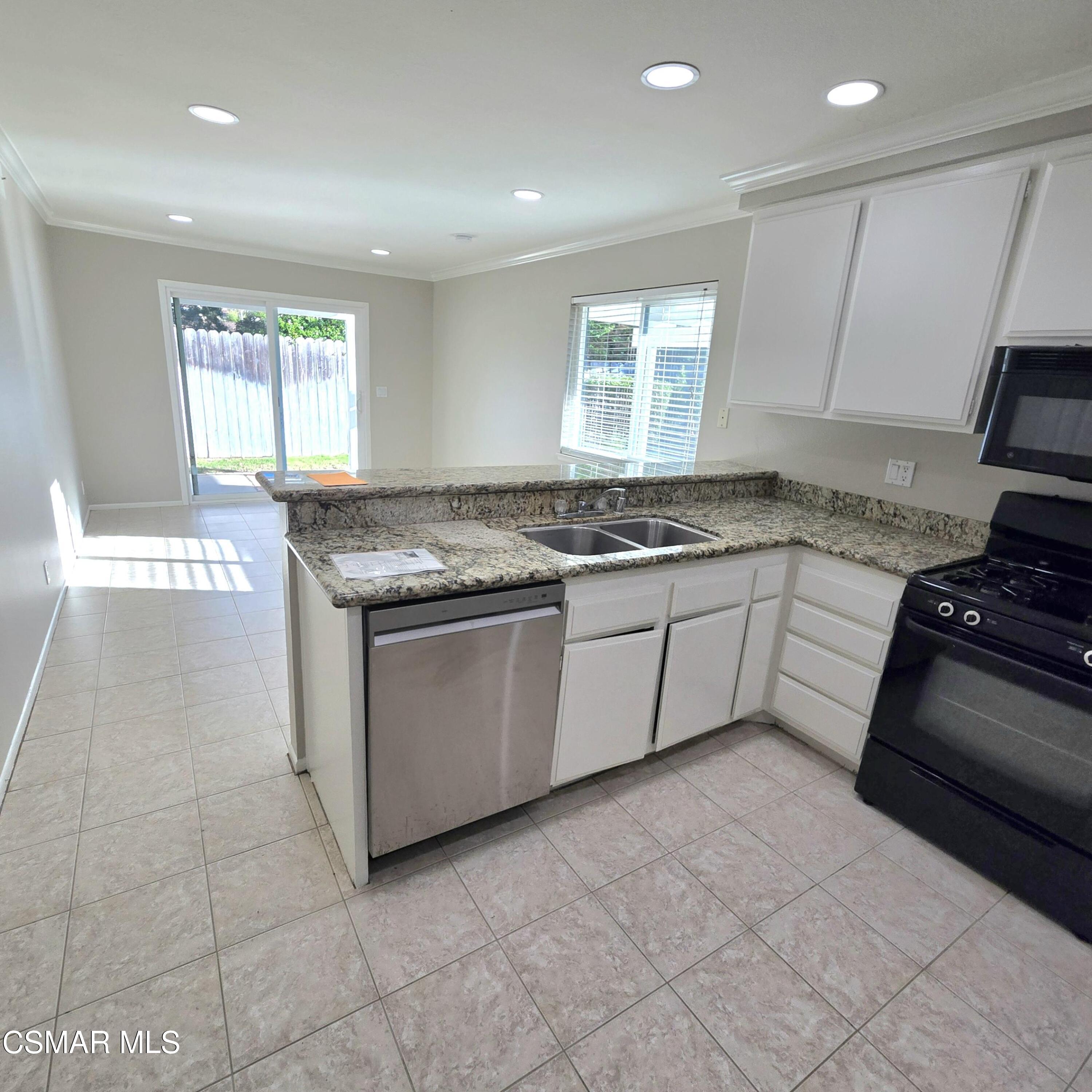 13568 East Quail Summit Road Moorpark, CA 93021 - Photo 8 of 20 a kitchen with stainless steel appliances granite countertop a stove a sink and a microwave