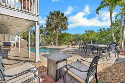 a view of a patio with table and chairs and potted plants with wooden floor and fence