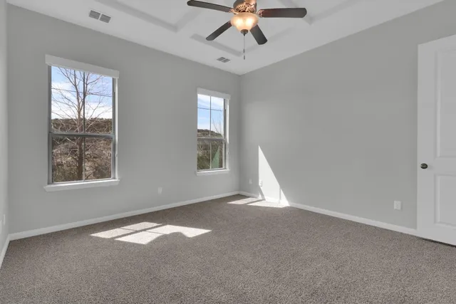a view of an empty room with glass door and windows