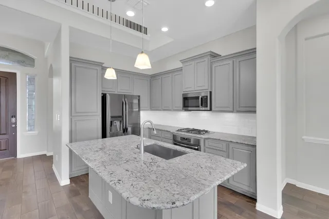 a kitchen with stainless steel appliances granite countertop a sink dishwasher stove and refrigerator
