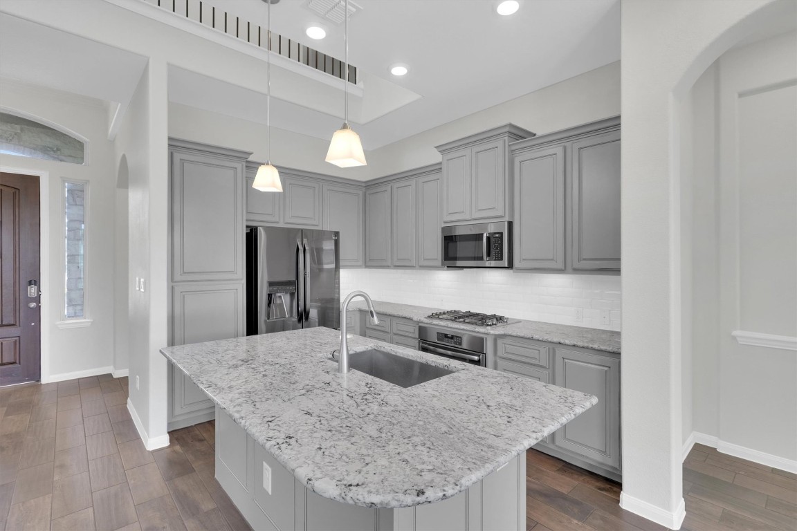 201 Cartwheel Bend, Unit 30 Austin, TX 78738 - Photo 3 of 40 a kitchen with stainless steel appliances granite countertop a sink dishwasher stove and refrigerator