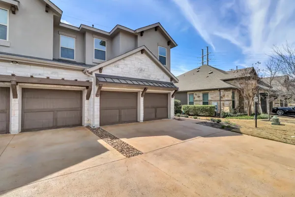 a view of a brick house with a large tree