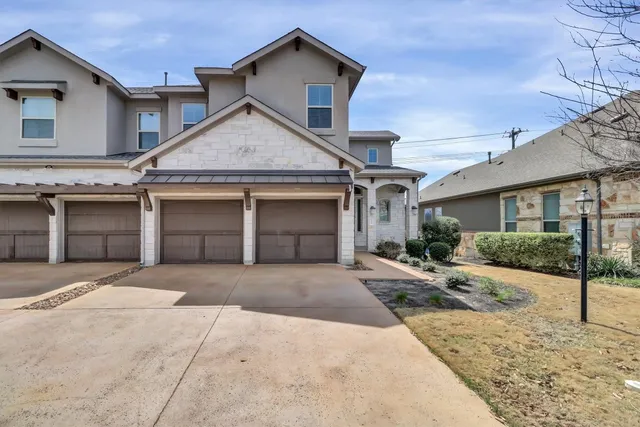 a view of a brick house with a large tree