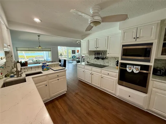 a kitchen that has a sink cabinets counter space and appliances