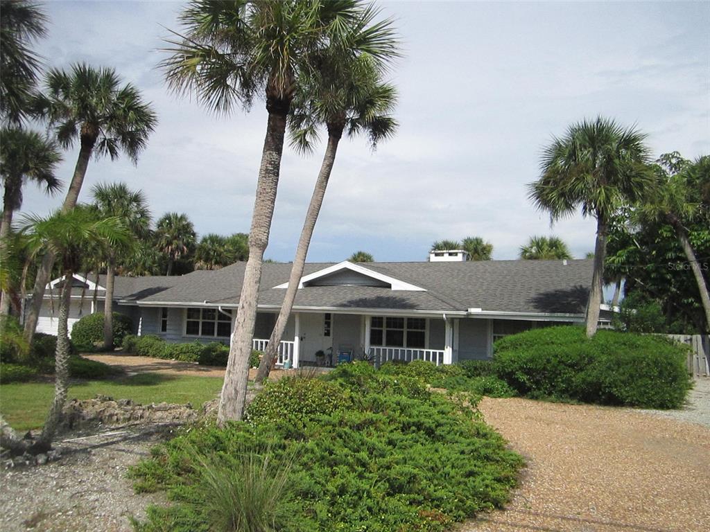 3534 Casey Key Road Nokomis, FL 34275 - Photo 2 of 55 a front view of a house with a garden