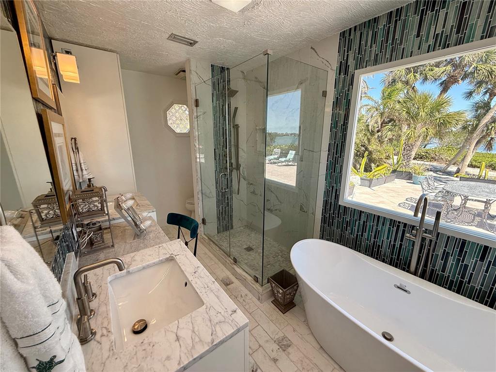 3534 Casey Key Road Nokomis, FL 34275 - Photo 29 of 55 a bathroom with a sink mirror bathtub and toilet