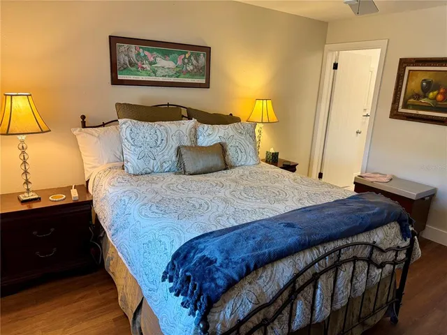a bedroom with a bed and a flat tv screen on dresser