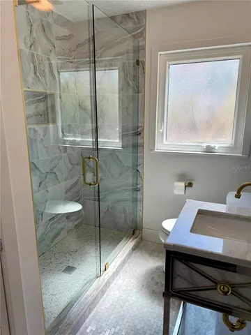 a bathroom with a toilet a sink and mirror