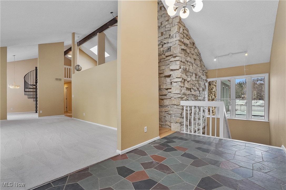 1094 San Raphael Drive Akron, OH 44333 - Photo 9 of 50 Empty room featuring a chandelier, high vaulted ceiling, stairs, track lighting, and beamed ceiling