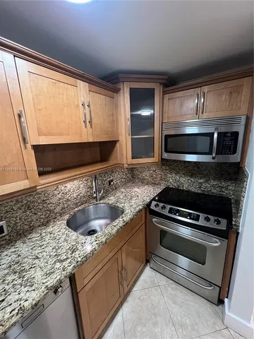 a kitchen with granite countertop a sink and stainless steel appliances