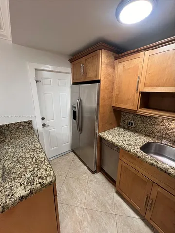 a kitchen with stainless steel appliances granite countertop a refrigerator and a stove