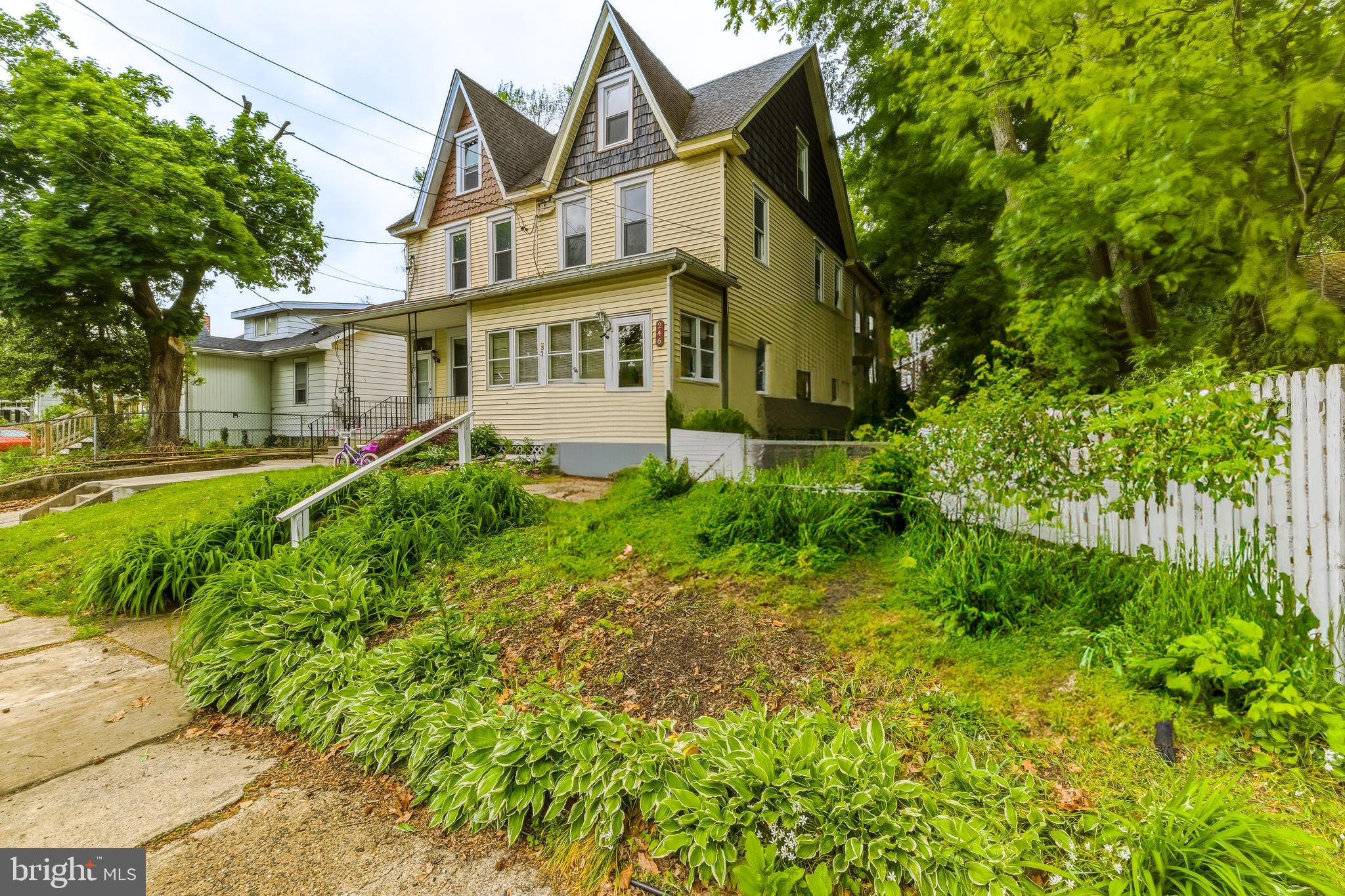 a view of a house with a big yard and large trees
