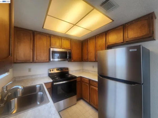 a kitchen with a refrigerator sink and stove top oven