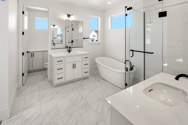 a spacious bathroom with a double vanity sink mirror and shower