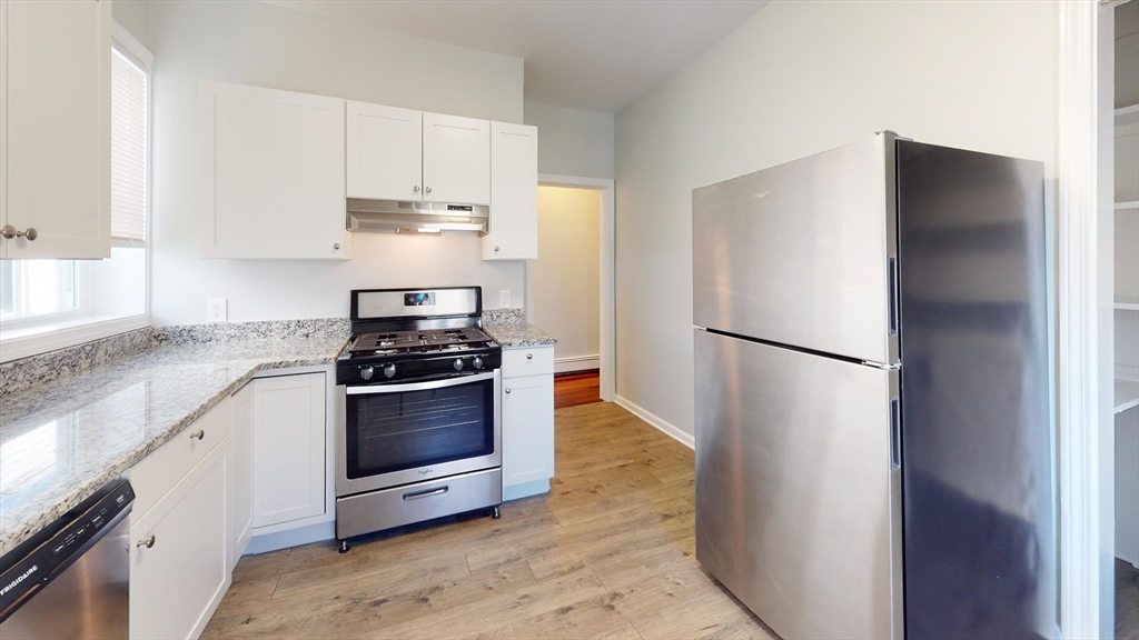 108 Boston Street, Unit 2 Boston, MA 02125 - Photo 2 of 10 a kitchen with stainless steel appliances granite countertop a refrigerator and a stove