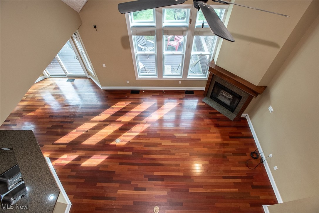 630 Rundle Street Lagrange, OH 44050 - Photo 37 of 49 Unfurnished living room featuring a glass covered fireplace, plenty of natural light, dark wood-style floors, ceiling fan, and high vaulted ceiling