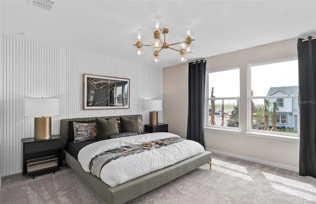 a bedroom with a large bed and a chandelier