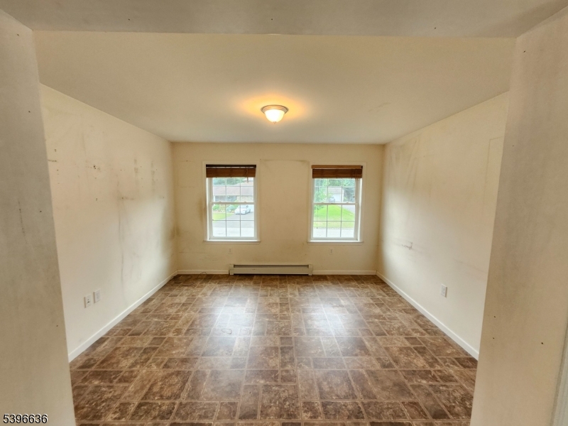 128 Big Piece Road Fairfield, NJ 07004 - Photo 11 of 22 an empty room with wooden floor and windows