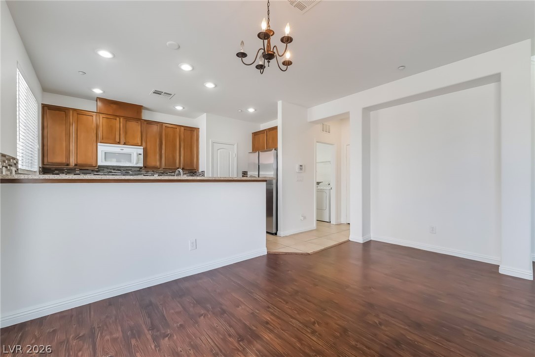 3175 Via Seranova Henderson, NV 89044 - Photo 11 of 45 This inviting space combines comfortable living with a well-appointed kitchen, featuring rich wood floors.