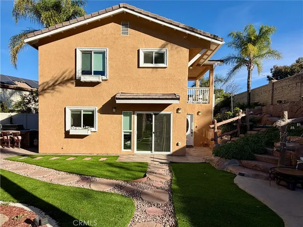 a front view of a house with a yard and potted plants