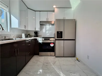 a kitchen with a sink dishwasher a stove and cabinets