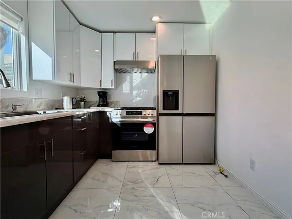 a kitchen with a sink dishwasher a stove and cabinets