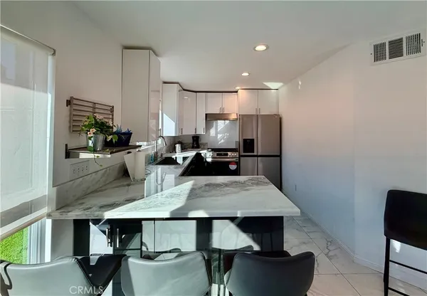 a view of kitchen with cabinets table and chairs