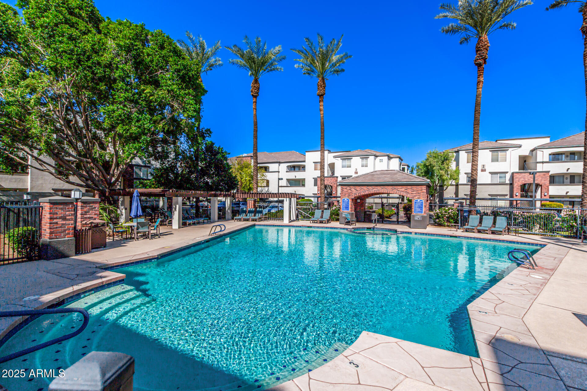 3302 North 7th Street, Unit 225 Phoenix, AZ 85014 - Photo 23 of 23 a view of a swimming pool with a table and chairs under an umbrella