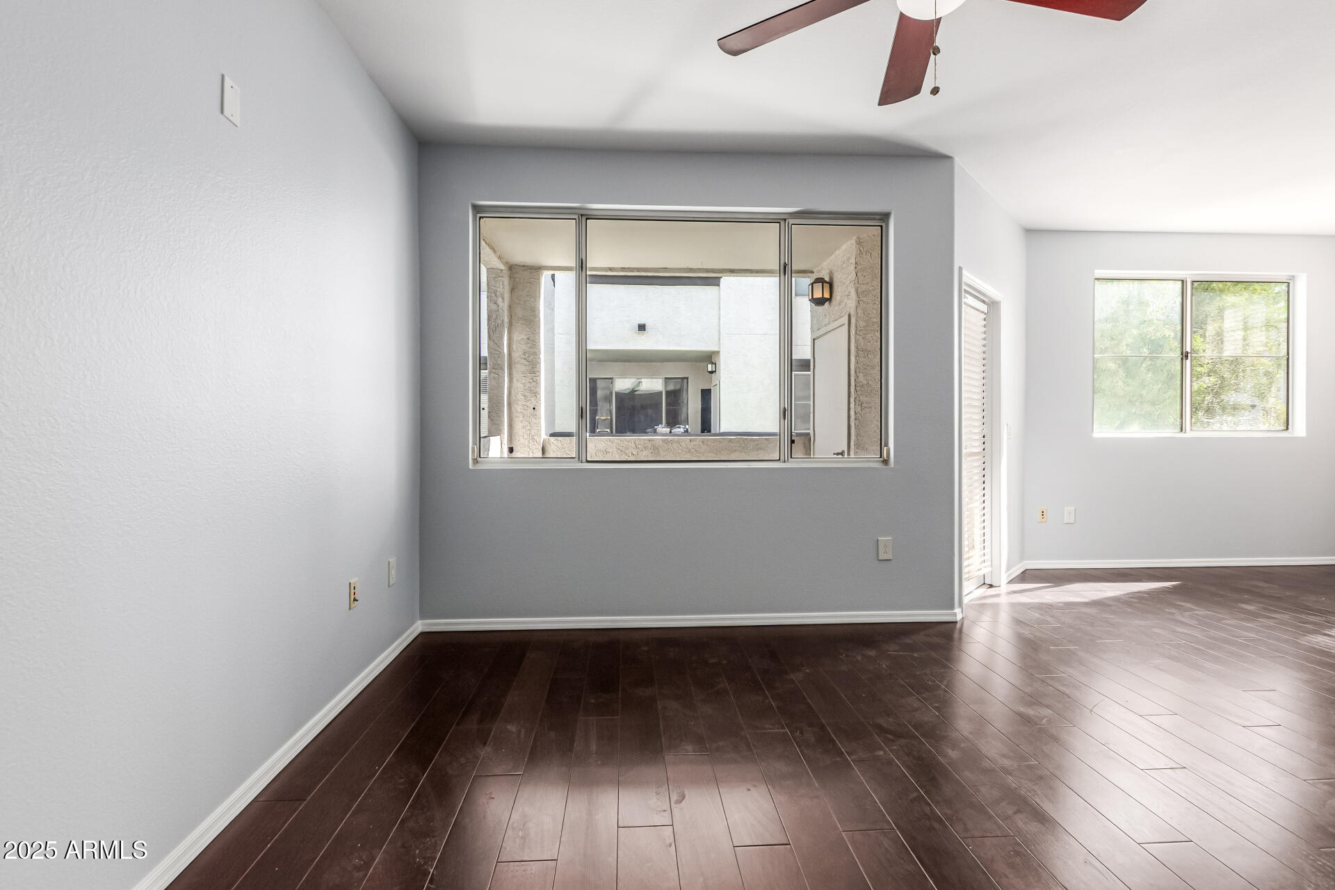 3302 North 7th Street, Unit 225 Phoenix, AZ 85014 - Photo 4 of 23 an empty room with wooden floor fan and windows