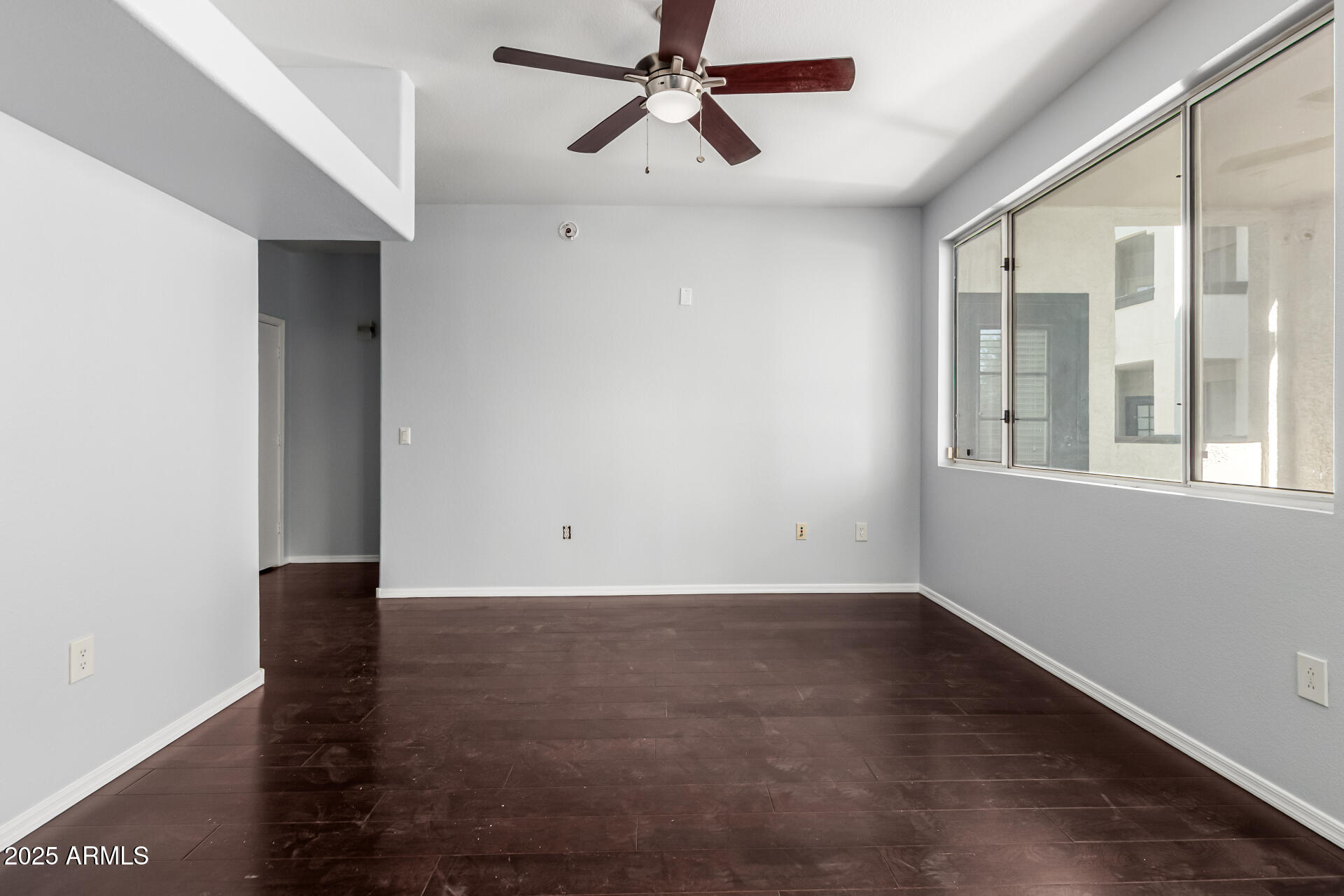 3302 North 7th Street, Unit 225 Phoenix, AZ 85014 - Photo 5 of 23 a view of an empty room with wooden floor and a window