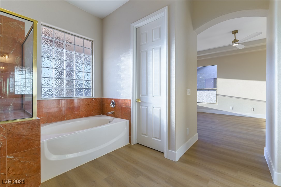 379 Marlin Cove Road Henderson, NV 89012 - Photo 19 of 22 Bathroom with a garden tub, wood finished floors, and ceiling fan