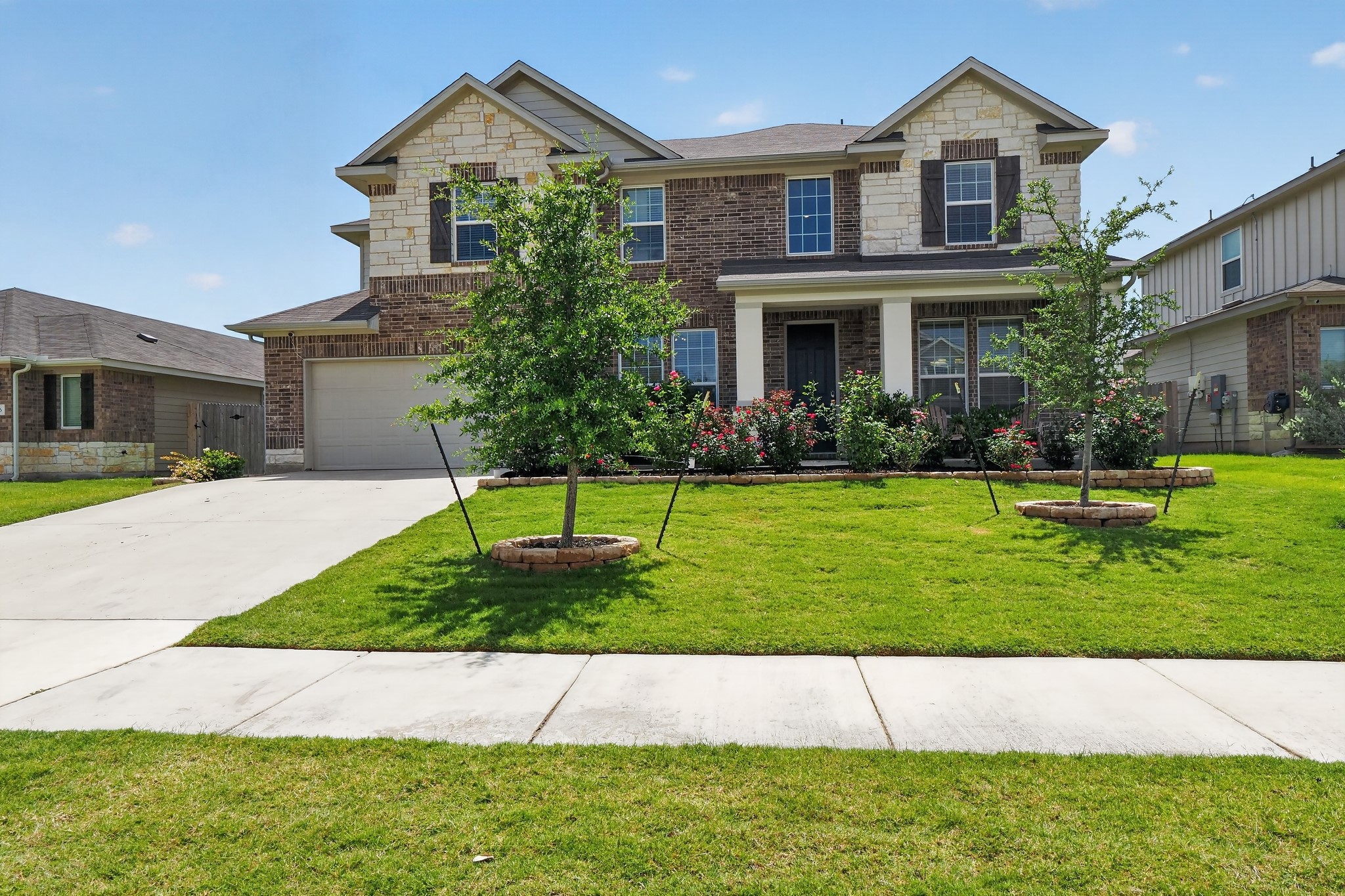 114 Bosco Road Hutto, TX 78634 - Photo 2 of 39 A welcoming facade with a well-maintained lawn and established landscaping invites you home.