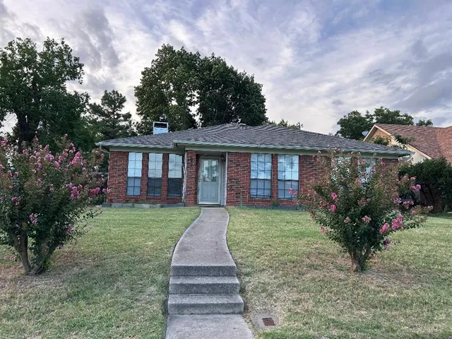 a front view of a house with a yard garden and outdoor seating