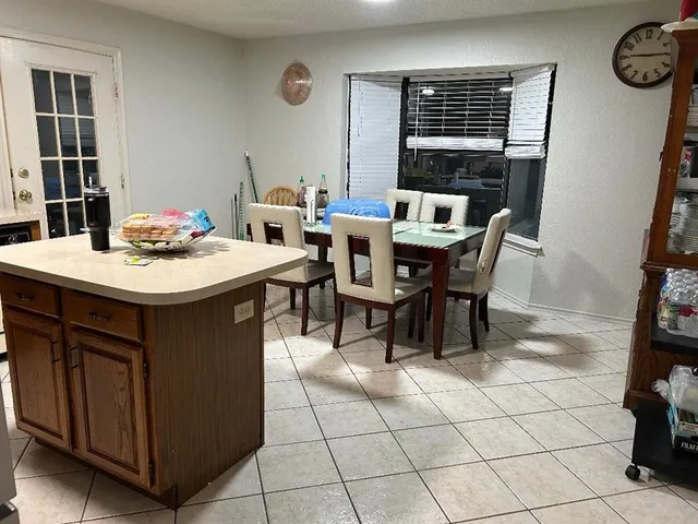 a open dining room with stainless steel appliances a table and chairs