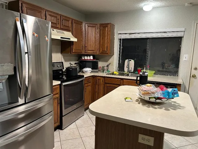 a kitchen with a sink a refrigerator and cabinets