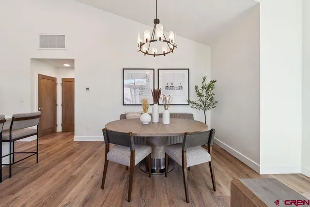 a view of a dining room with furniture wooden floor and chandelier