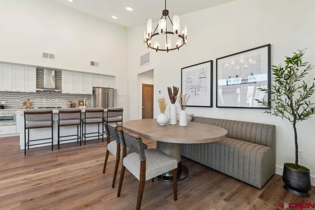 a kitchen with stainless steel appliances a dining table chairs stove microwave and cabinets