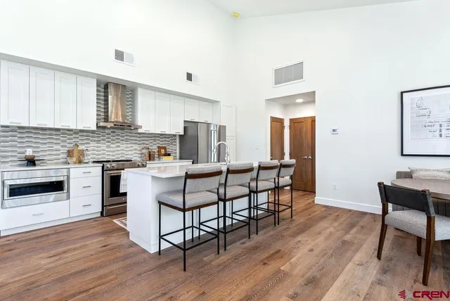 a living room with furniture a flat screen tv and floor to ceiling window