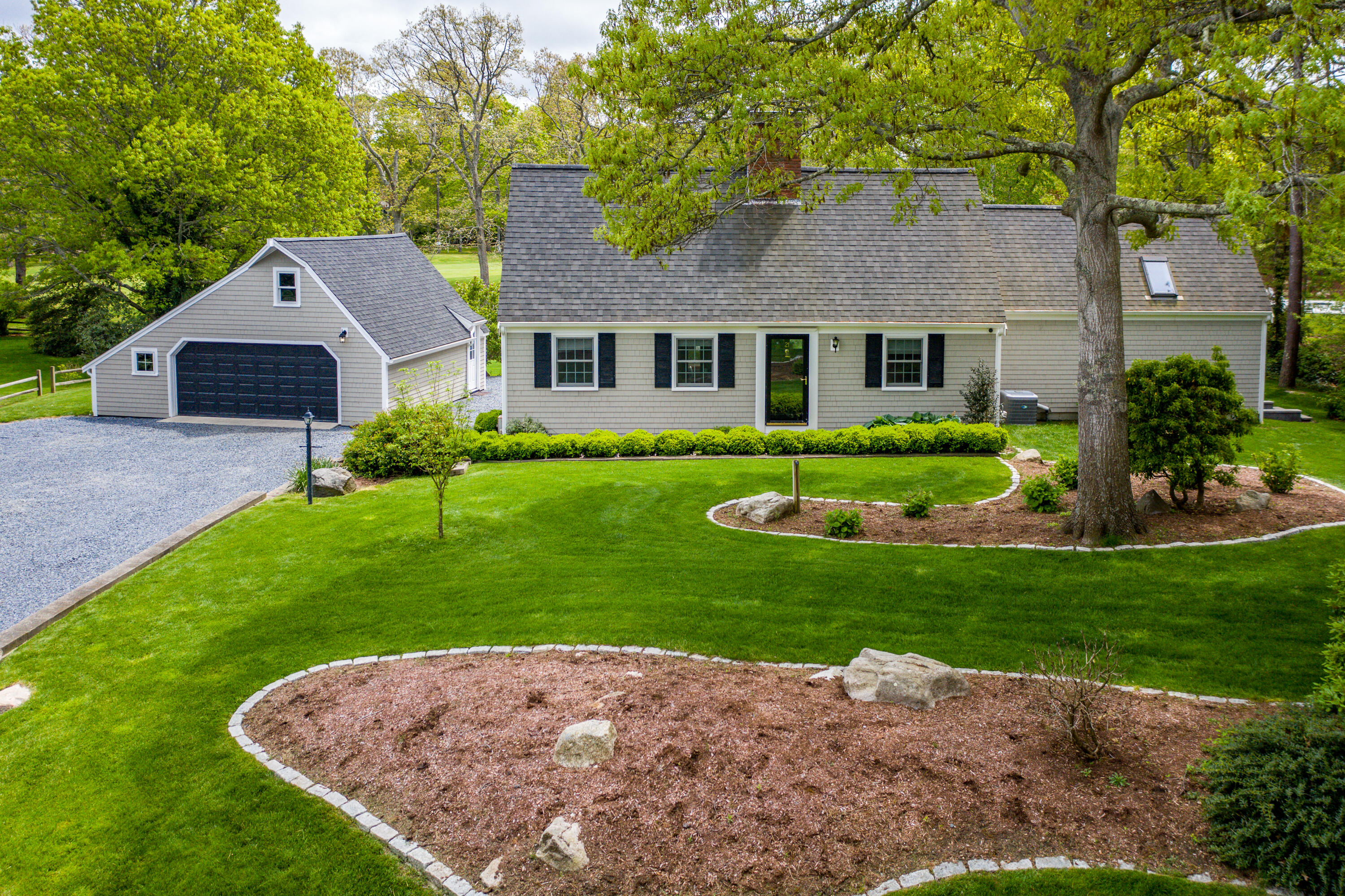 21 Midpine Road Cummaquid, MA 02675 - Photo 2 of 32 a front view of a house with a yard and garage