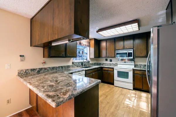 a kitchen with stainless steel appliances granite countertop a sink stove and refrigerator