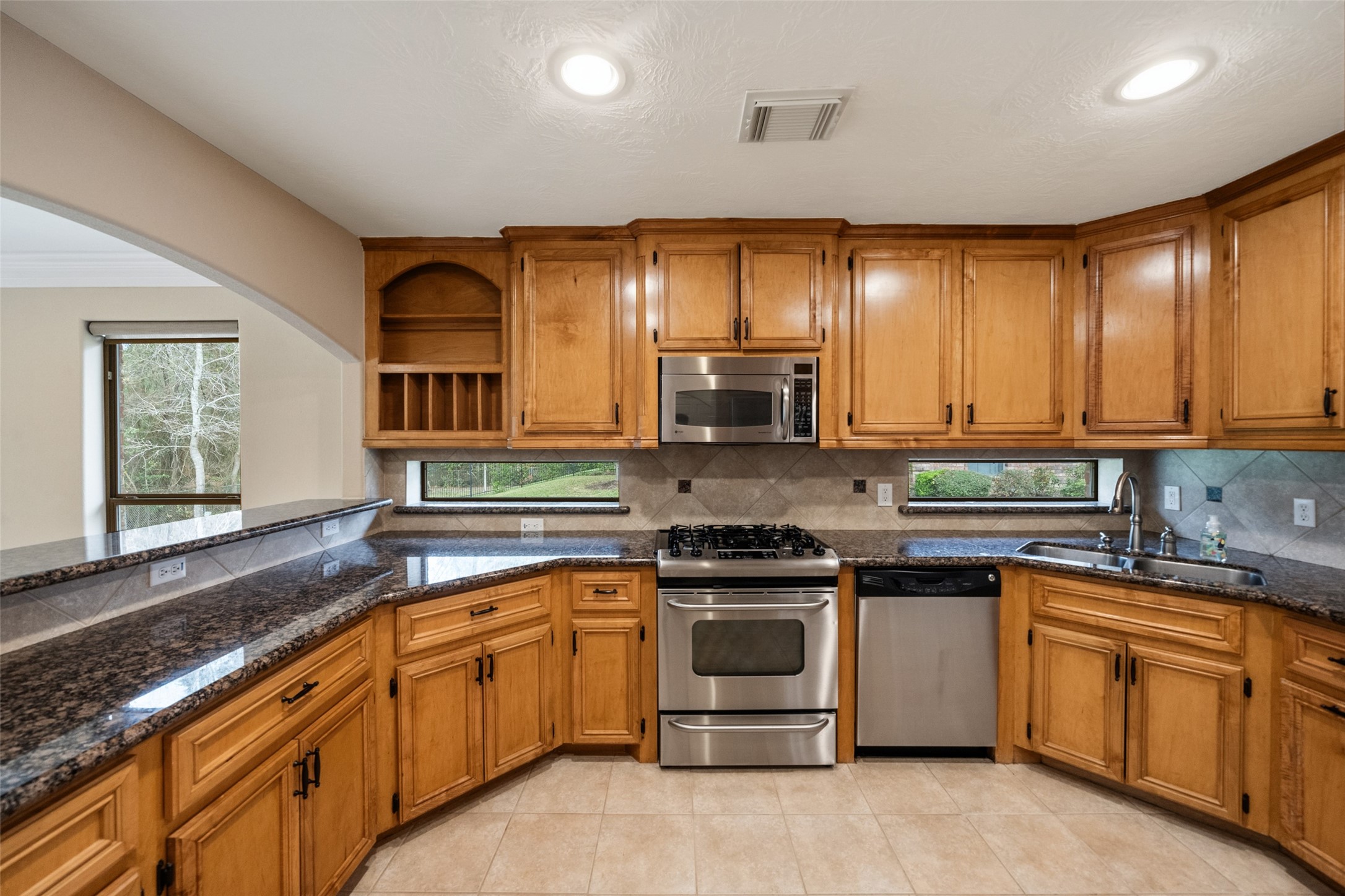 901 Longmire Road, Unit 28 Conroe, TX 77304 - Photo 11 of 31 a kitchen with kitchen island granite countertop white cabinets sink and stainless steel appliances