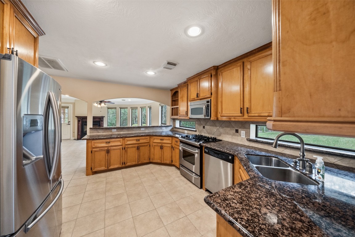 901 Longmire Road, Unit 28 Conroe, TX 77304 - Photo 17 of 31 a kitchen with stainless steel appliances granite countertop a sink stove and refrigerator