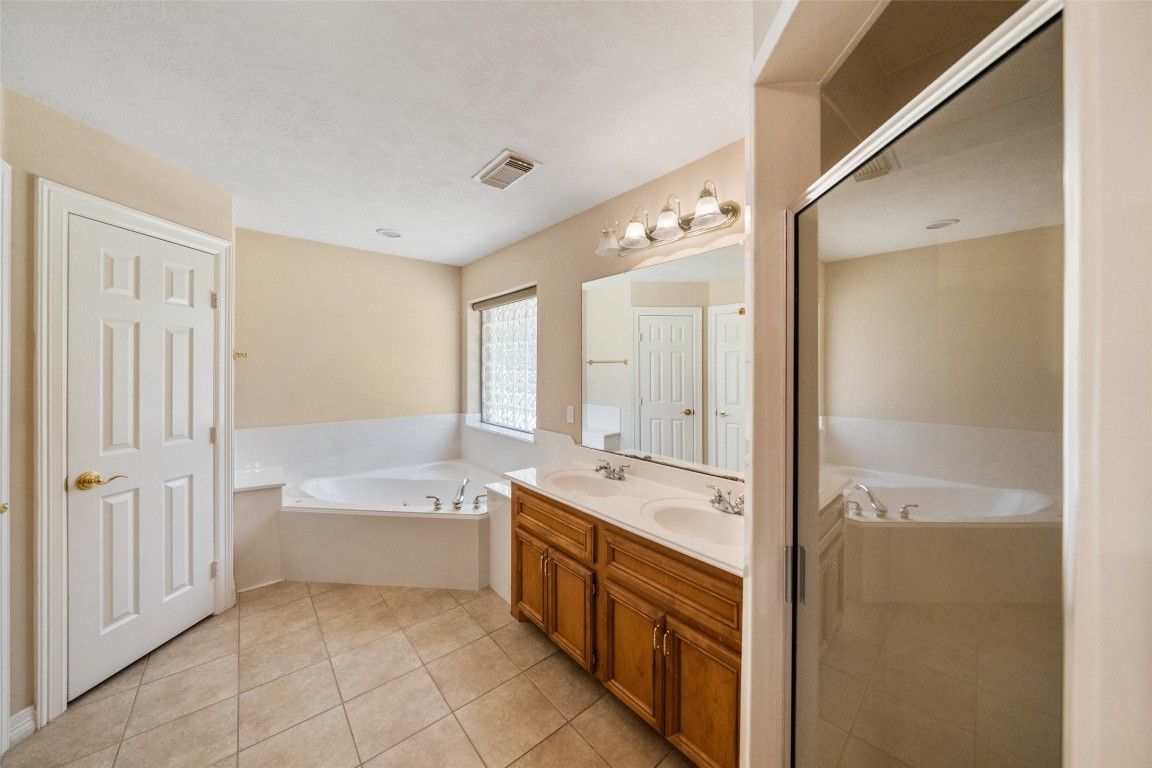 901 Longmire Road, Unit 28 Conroe, TX 77304 - Photo 24 of 31 a spacious bathroom with a tub sink shower and mirror